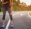 Jeune femme faisant son jogging, penchée en avant pour essayer de reprendre son souffle